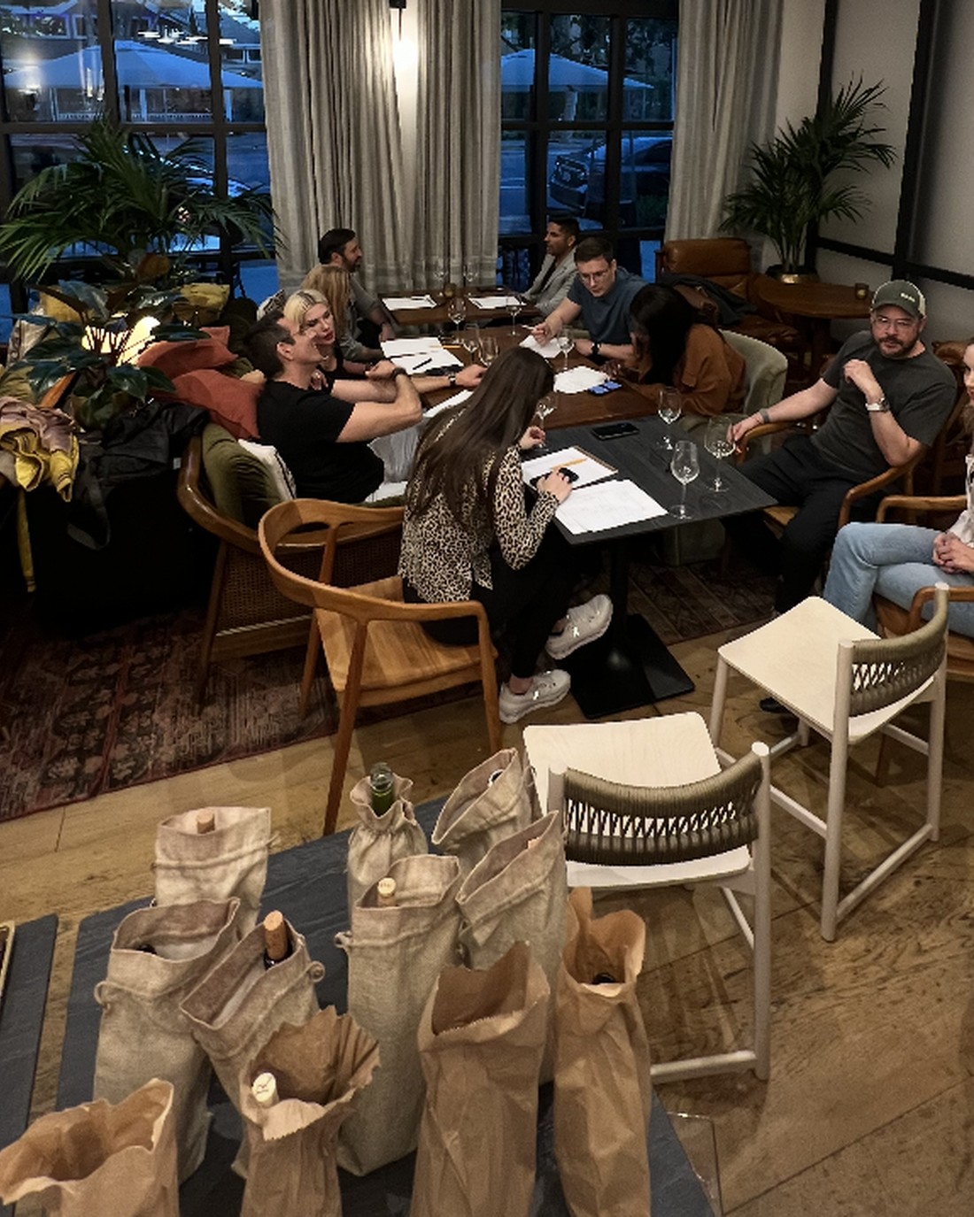 Numbered bottle bags and guests at a blind tasting.