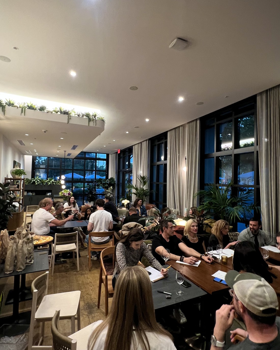 A room full of guests deep in a blind tasting, tasting sheets and glasses in front of them.