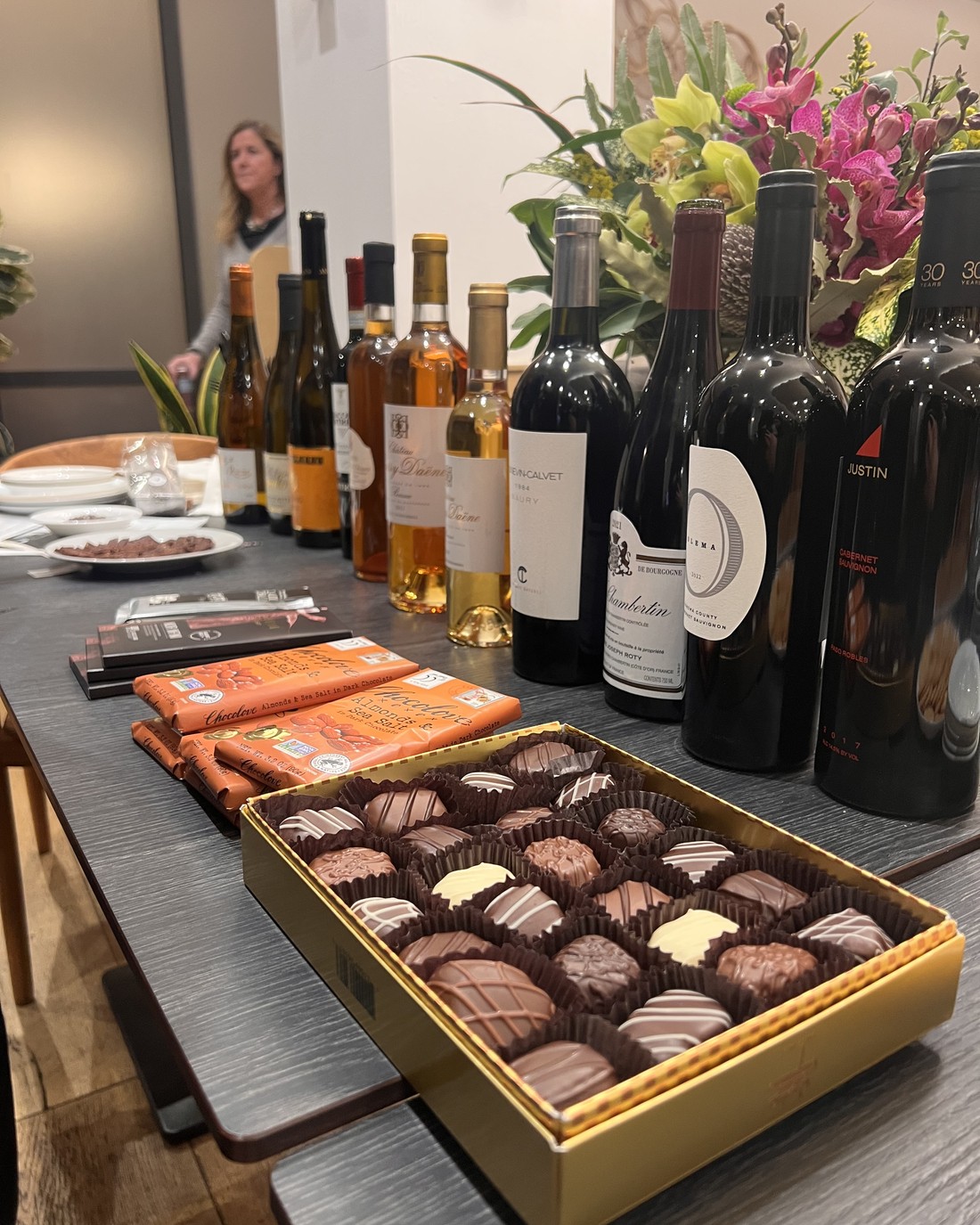 A chocolate spread beside dessert wines and reds from a seated tasting.