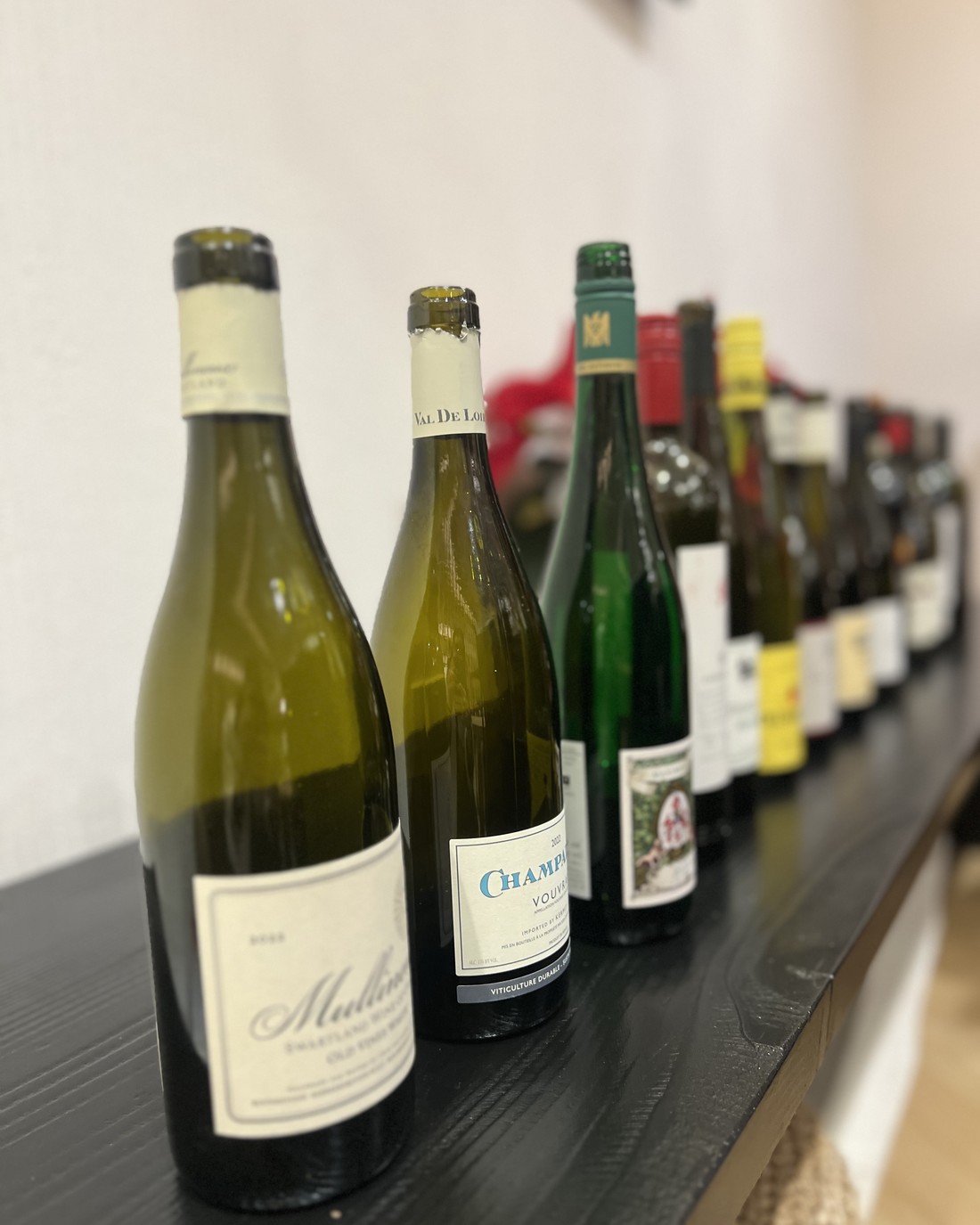Champalou Vouvray leading a lineup of bottles on a dark counter.